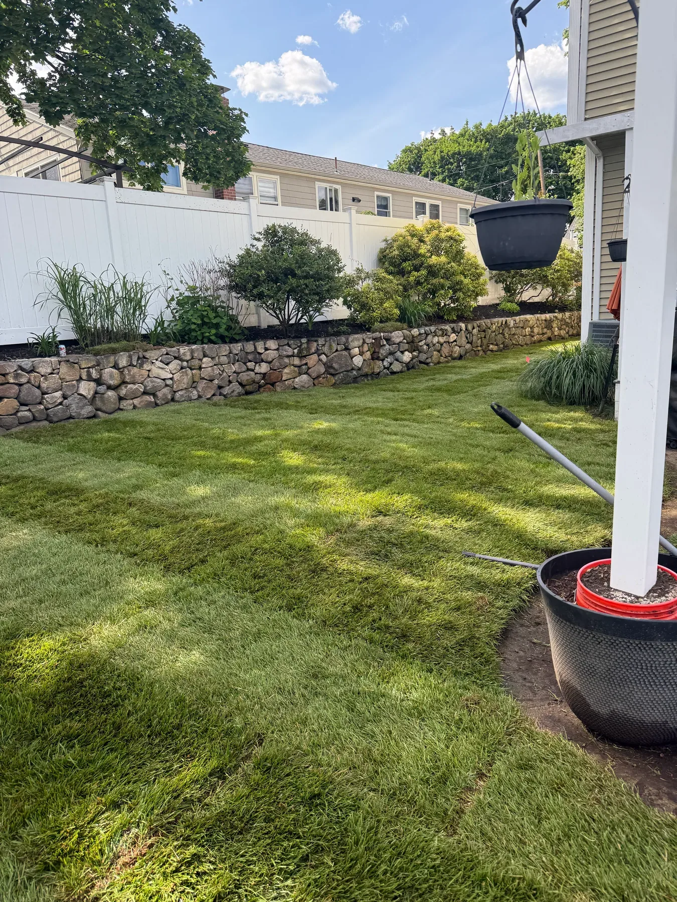 Maintained lawn, landscaped planting bed, and natural stone border by S.B. Landscaping