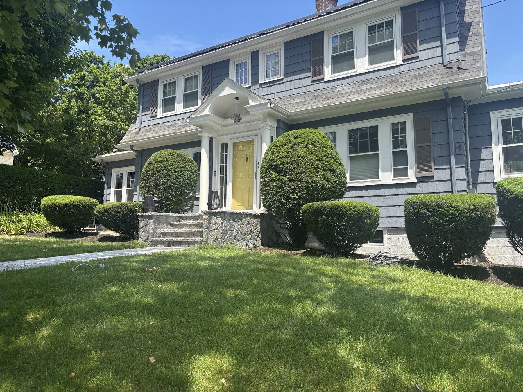 Trimmed boxwood shrubs and clean landscaping by S.B. Landscaping